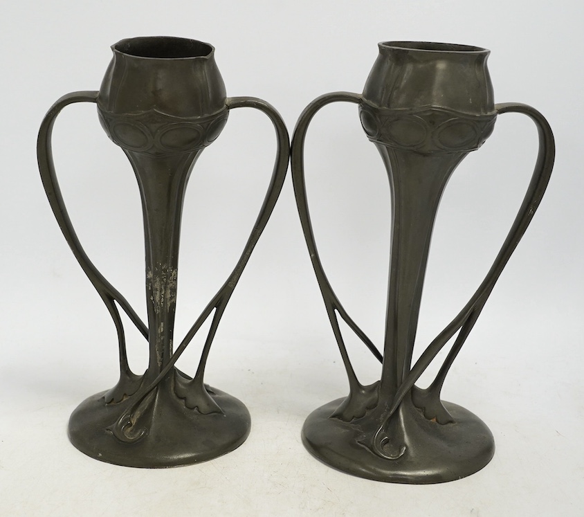 A pair of Art Nouveau Liberty Tudric pewter twin-handled vases, stamped to the bases, 25cm high. Condition - one good, the other poor to fair